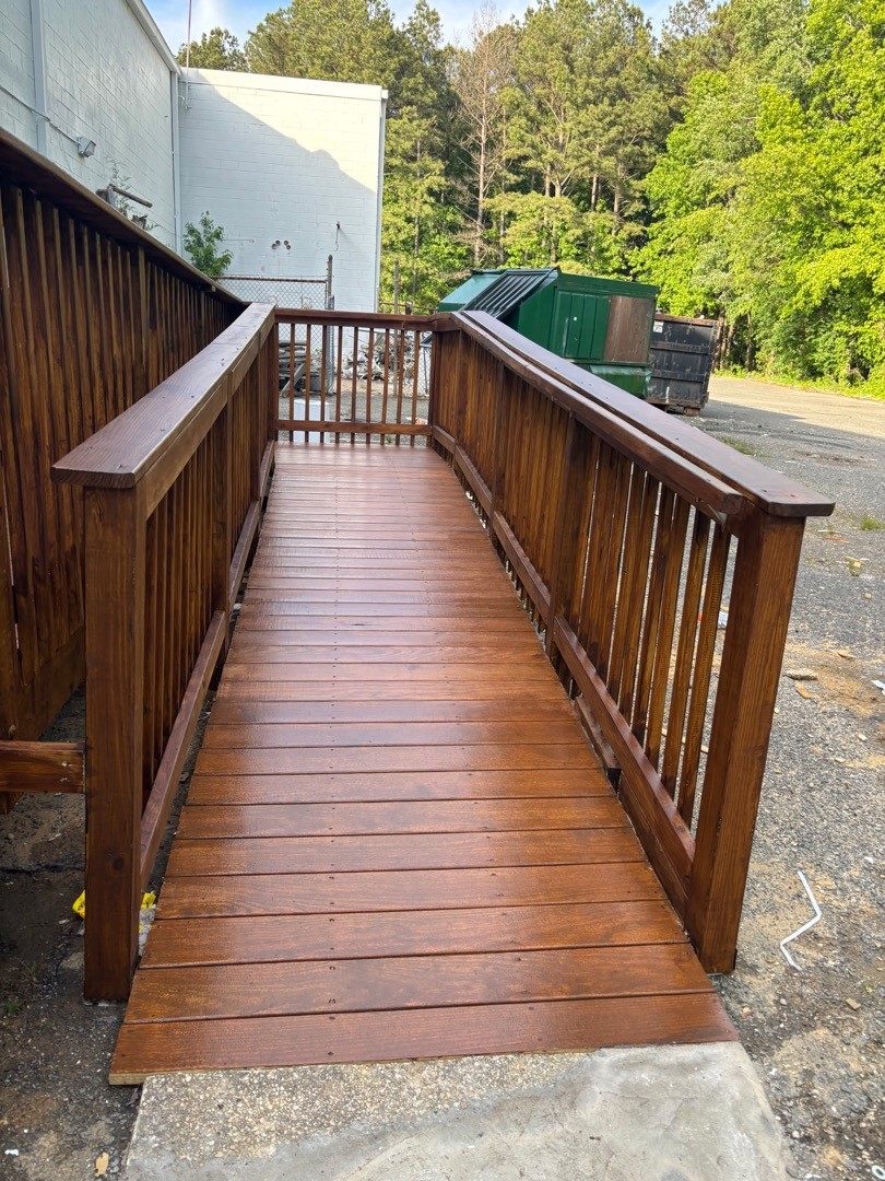 Completed accessible ramp with stained timber decking and handrails
