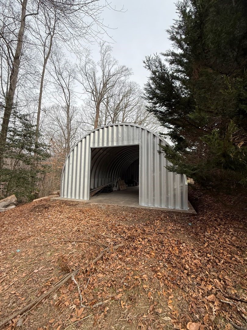 Completed arch steel outbuilding with an open bay door