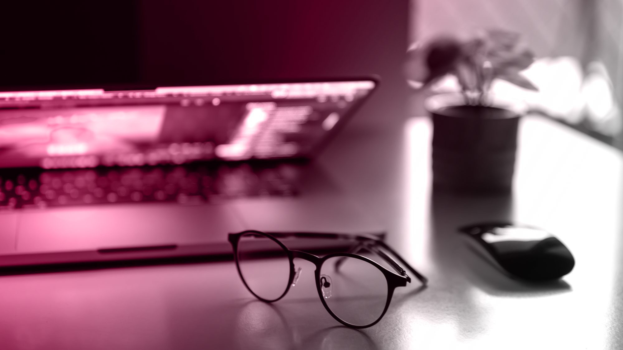 Eyeglasses on a desk in front of a laptop, representing web design for lead generation