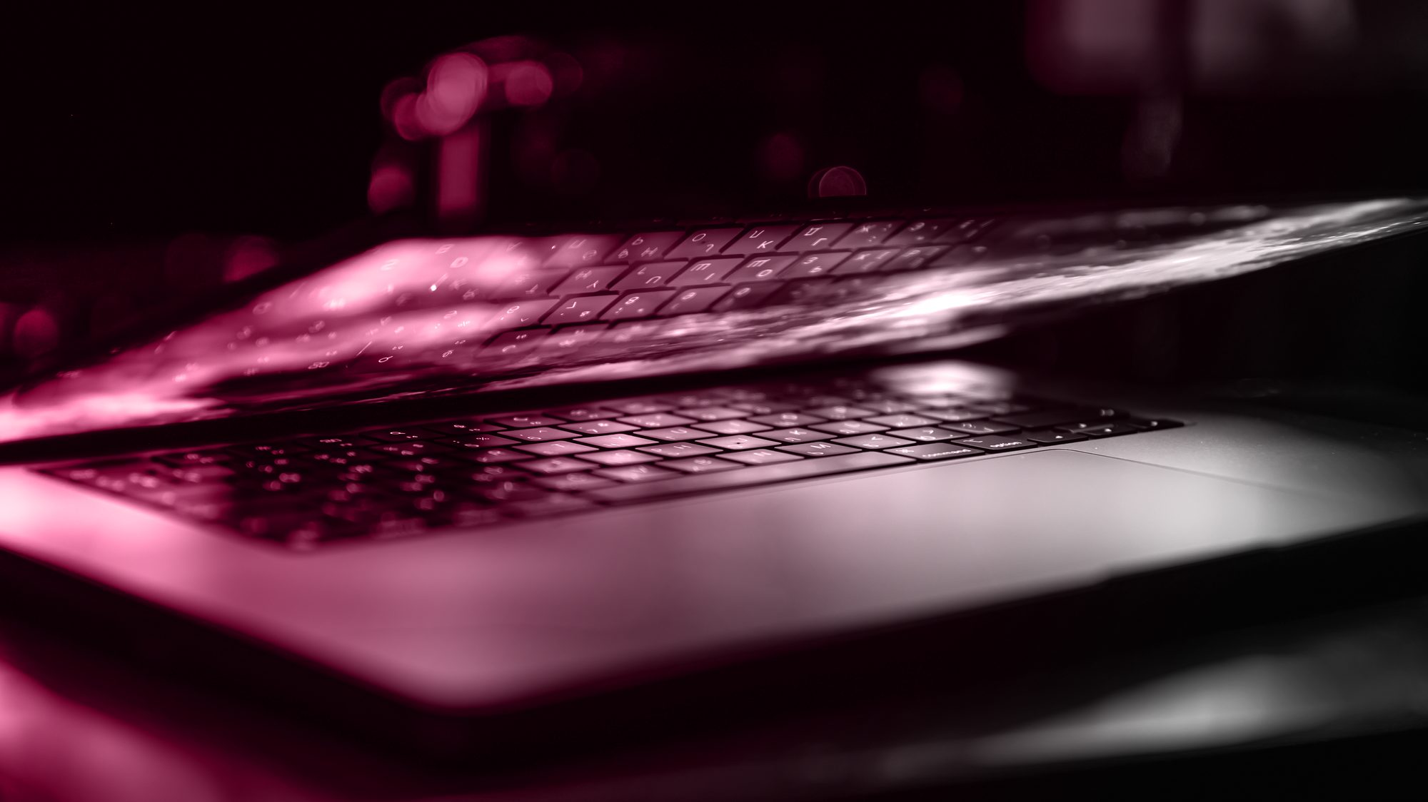 Dark laptop on a desk with colorful light reflections across the screen, illustrating website performance and Core Web Vitals