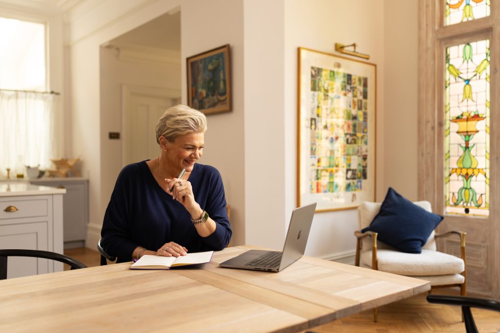 Woman with laptop on a dining table.