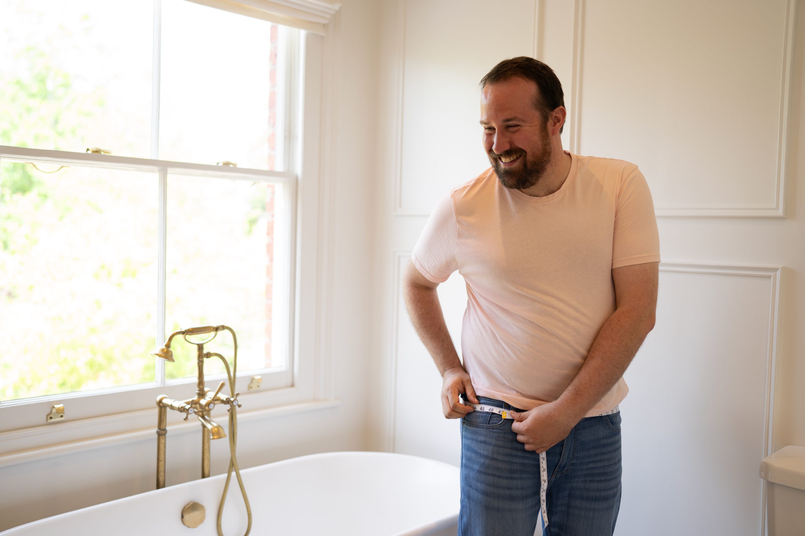 Man measuring his thigh with a tape measure.