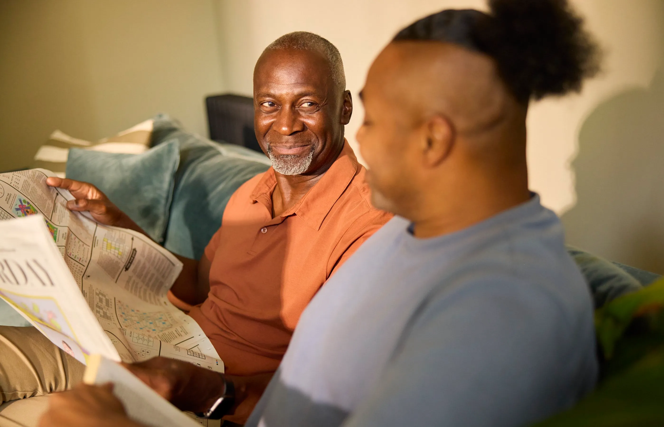 Two men talking together on a sofa