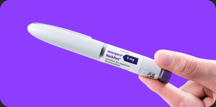 A hand holding the Mounjaro KwikPen