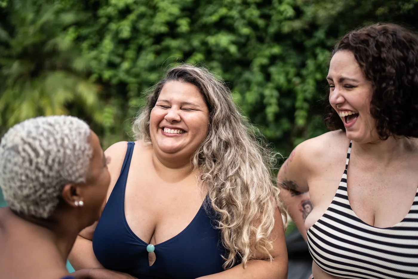 Three women laughing together outdoors