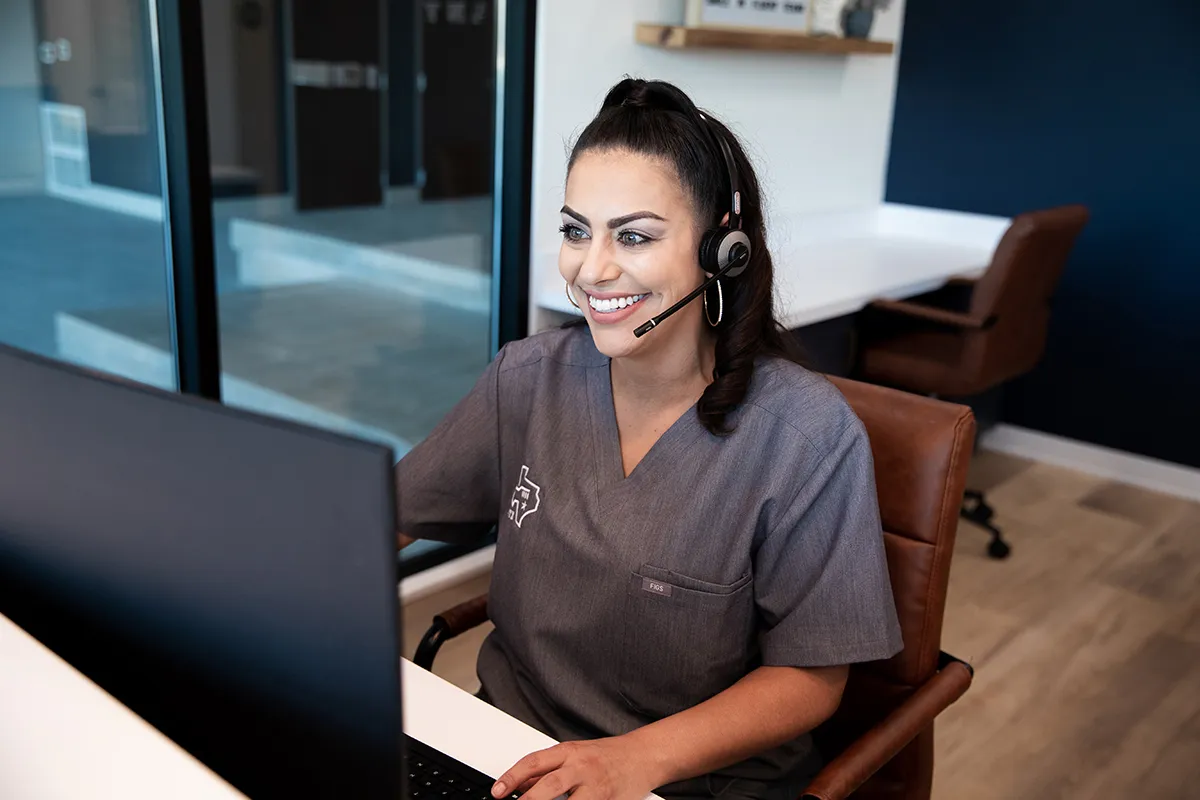Smiling and holding up her clear aligners