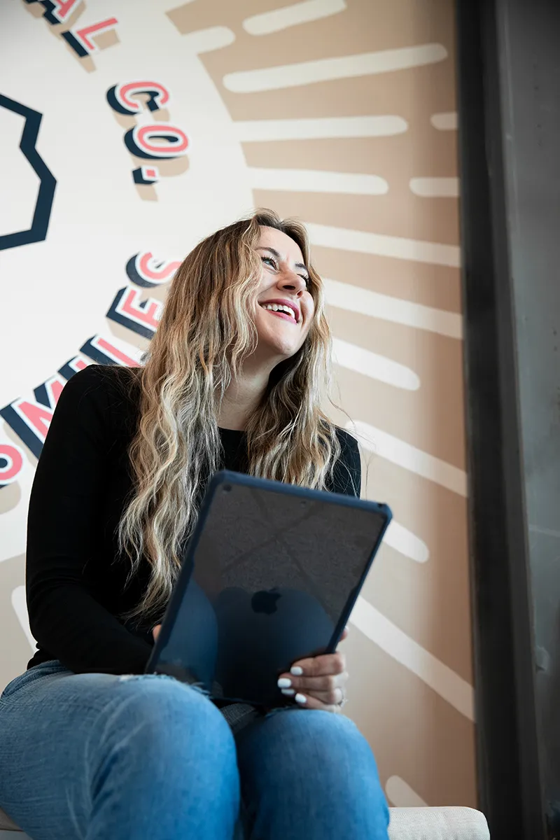 woman pointing to her bright white smile