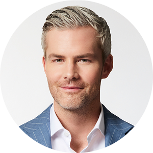 Portrait of a smiling man with blond hair wearing a blue blazer and white shirt.