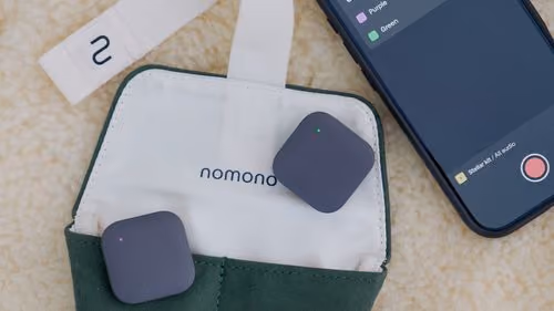 Nomono Stellar Kit with two small black microphones, one docked and one hovering.