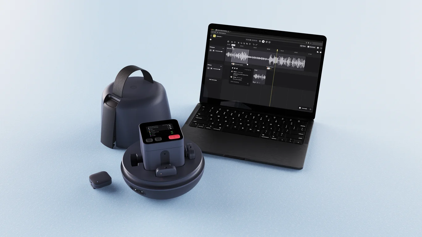 Laptop showing audio editing software next to audio recording and playback devices on blue surface.