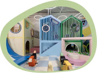 Indoor soft play area with colorful slides, tunnels, ball pit, and child-friendly climbing structures.