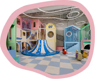 Colorful indoor playground with slides, climbing structures, and play equipment on checkered floor.