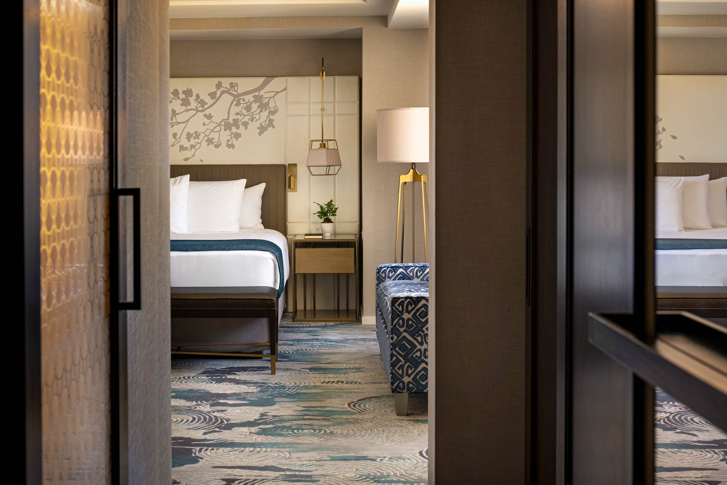 Hallway view into Japanese suite bedroom with bed and sofa.