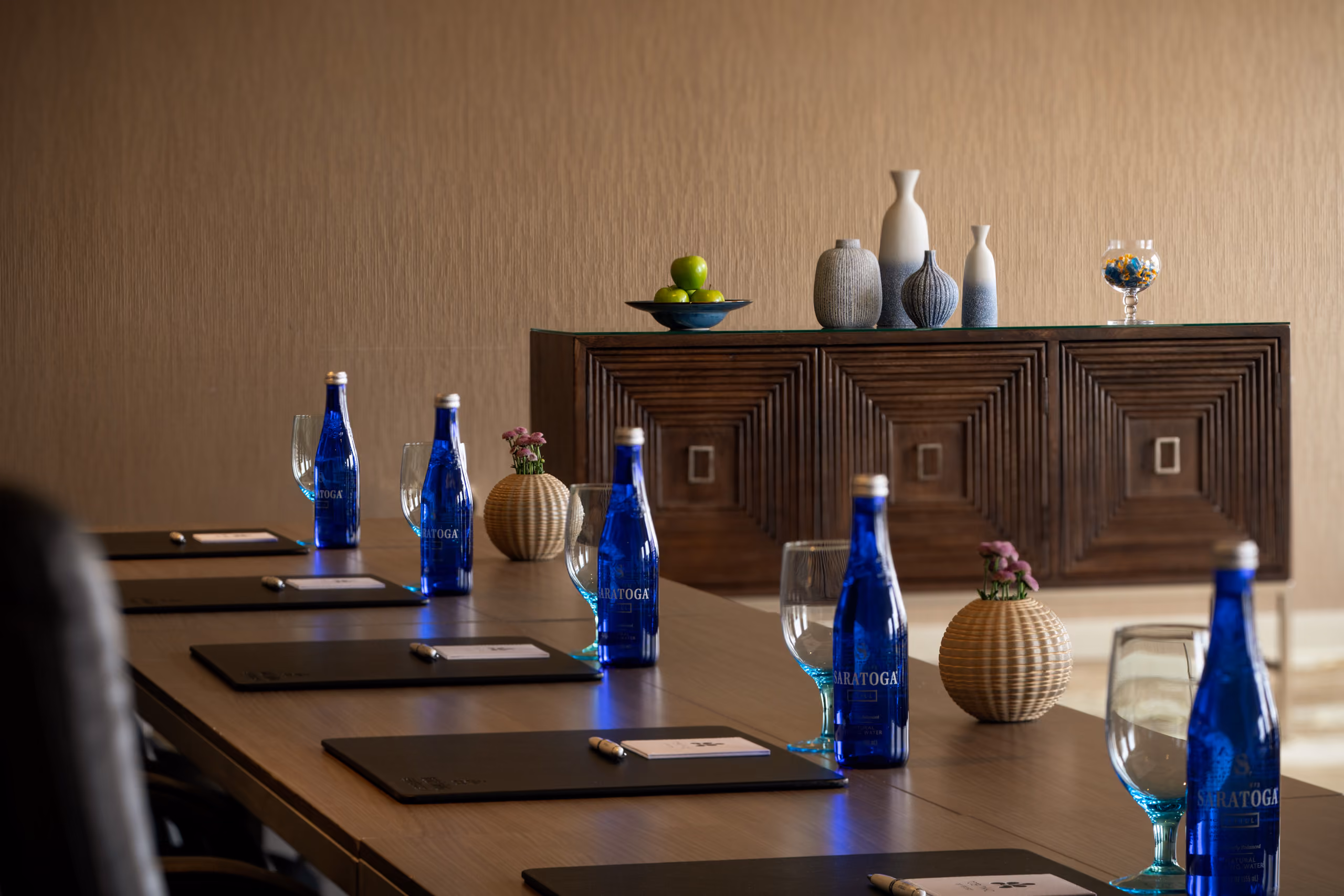 Conference table with blue water bottles and notepads.
