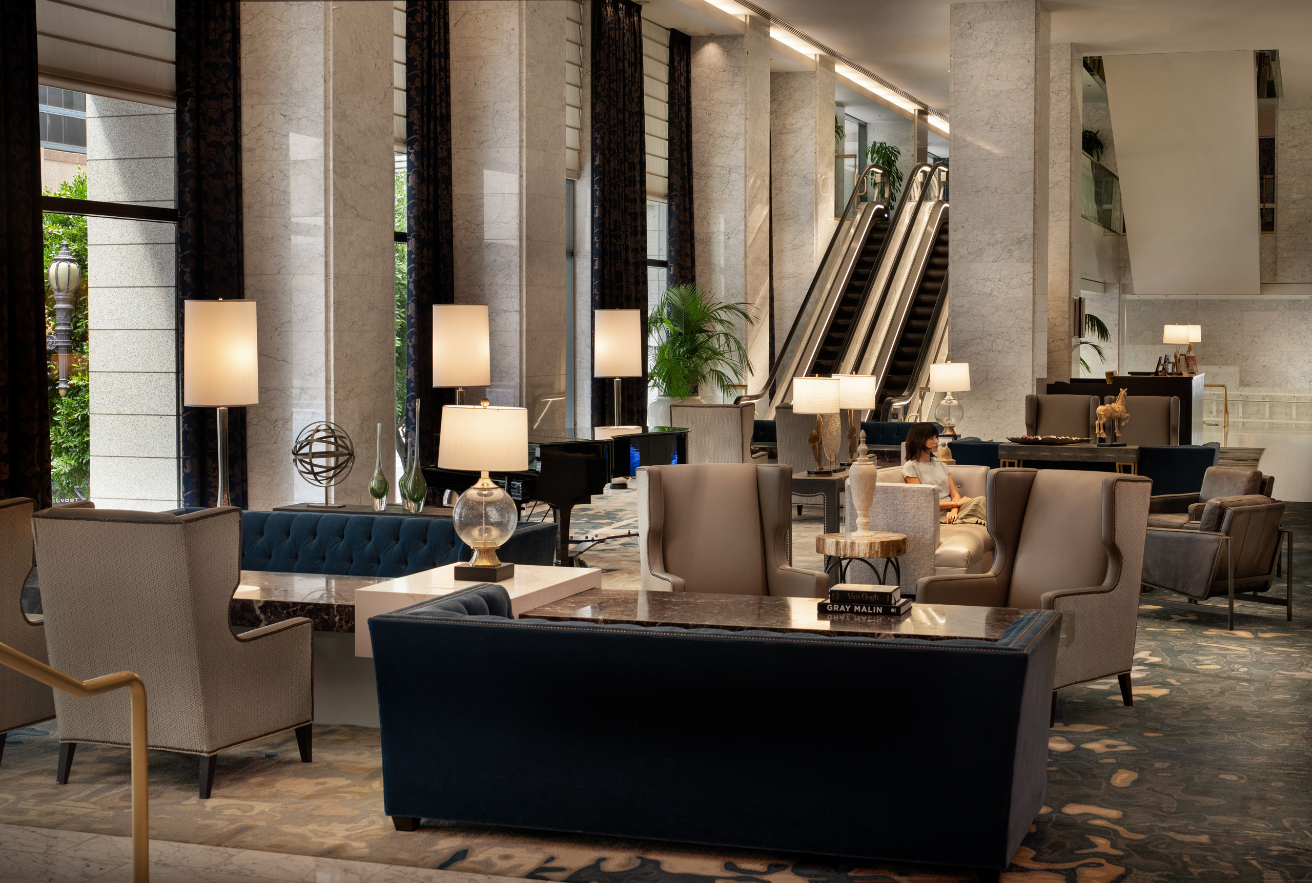 Hotel lobby with seating and escalators.