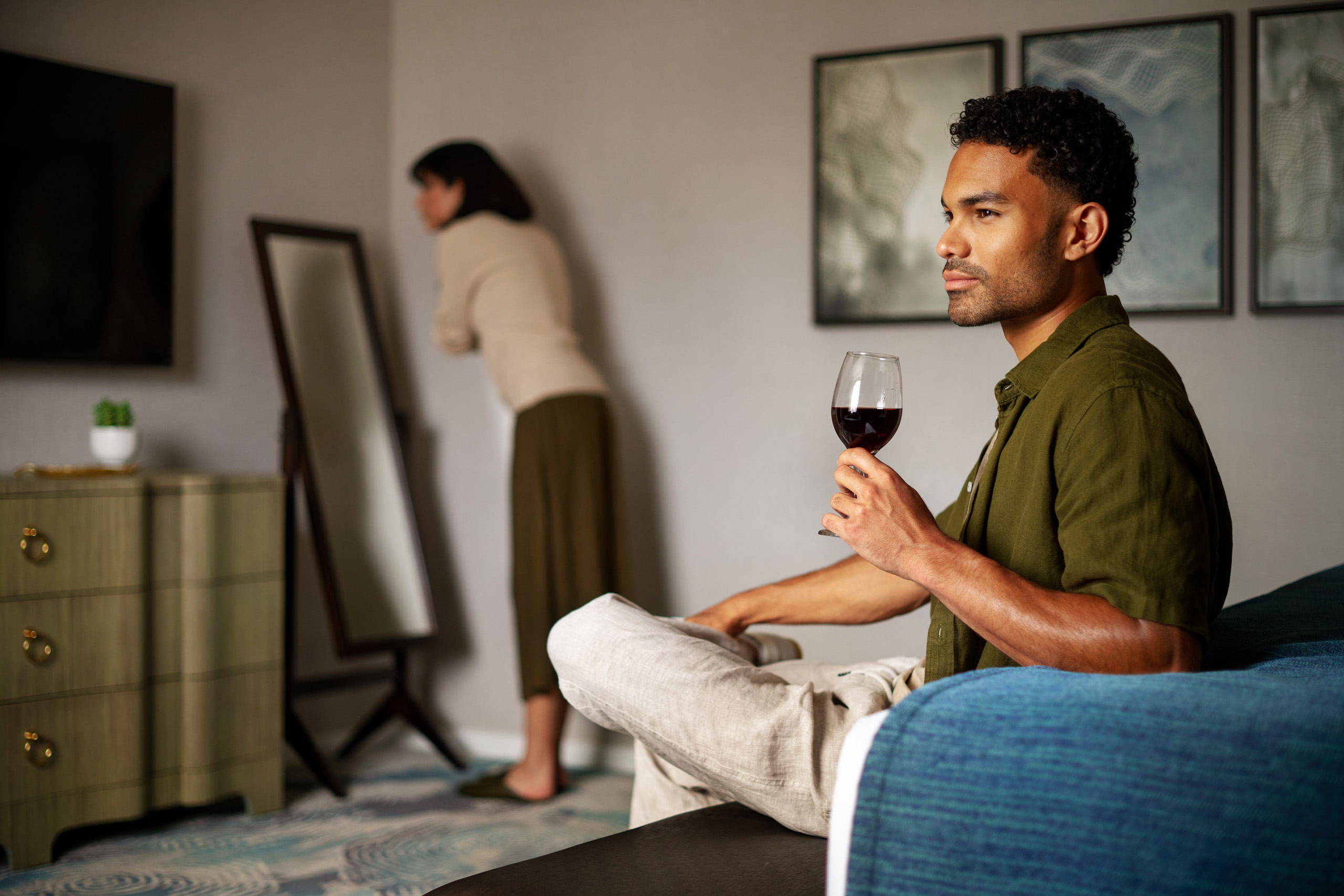 Man holding wine glass in hotel room