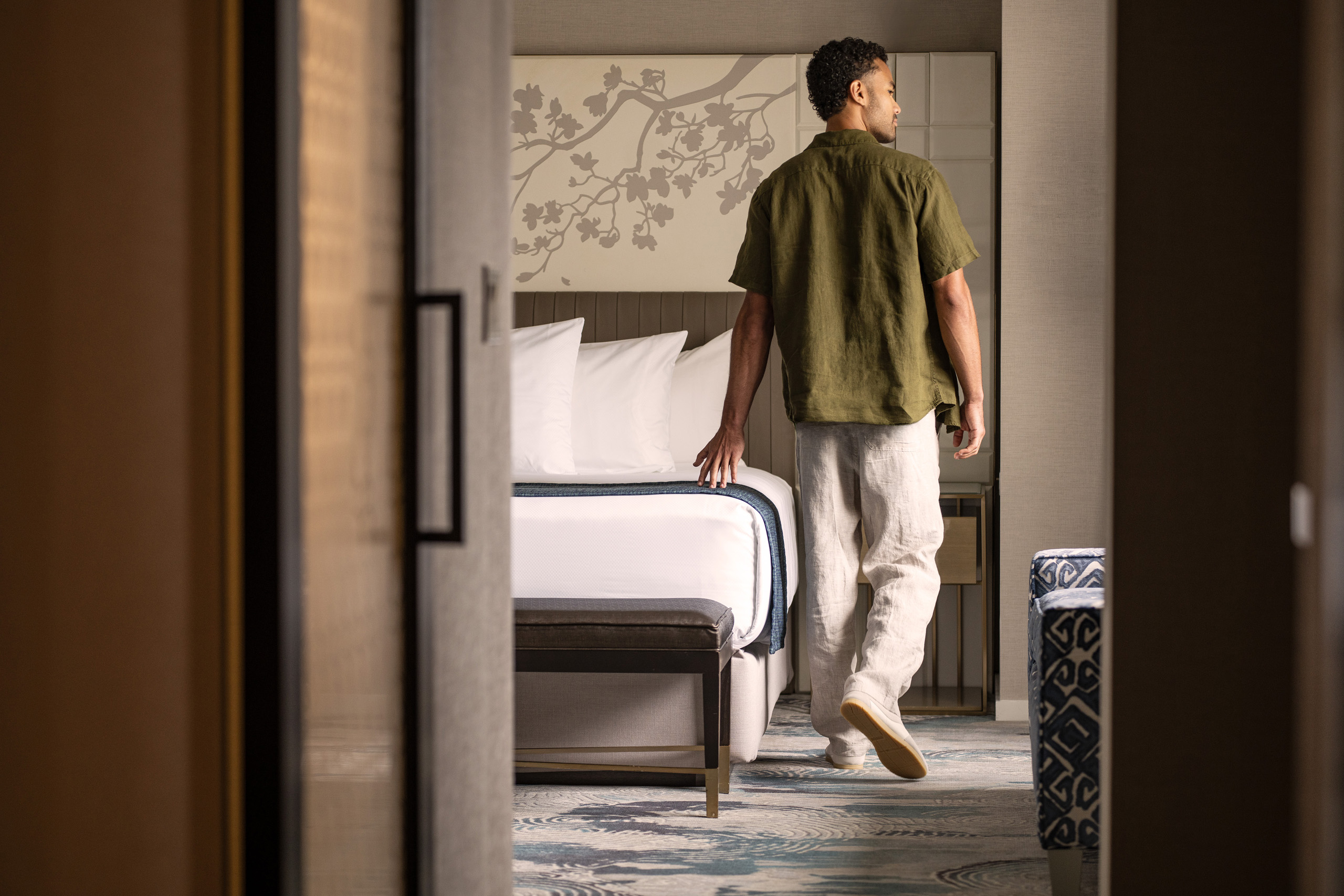 Guest walking toward bed in hotel suite