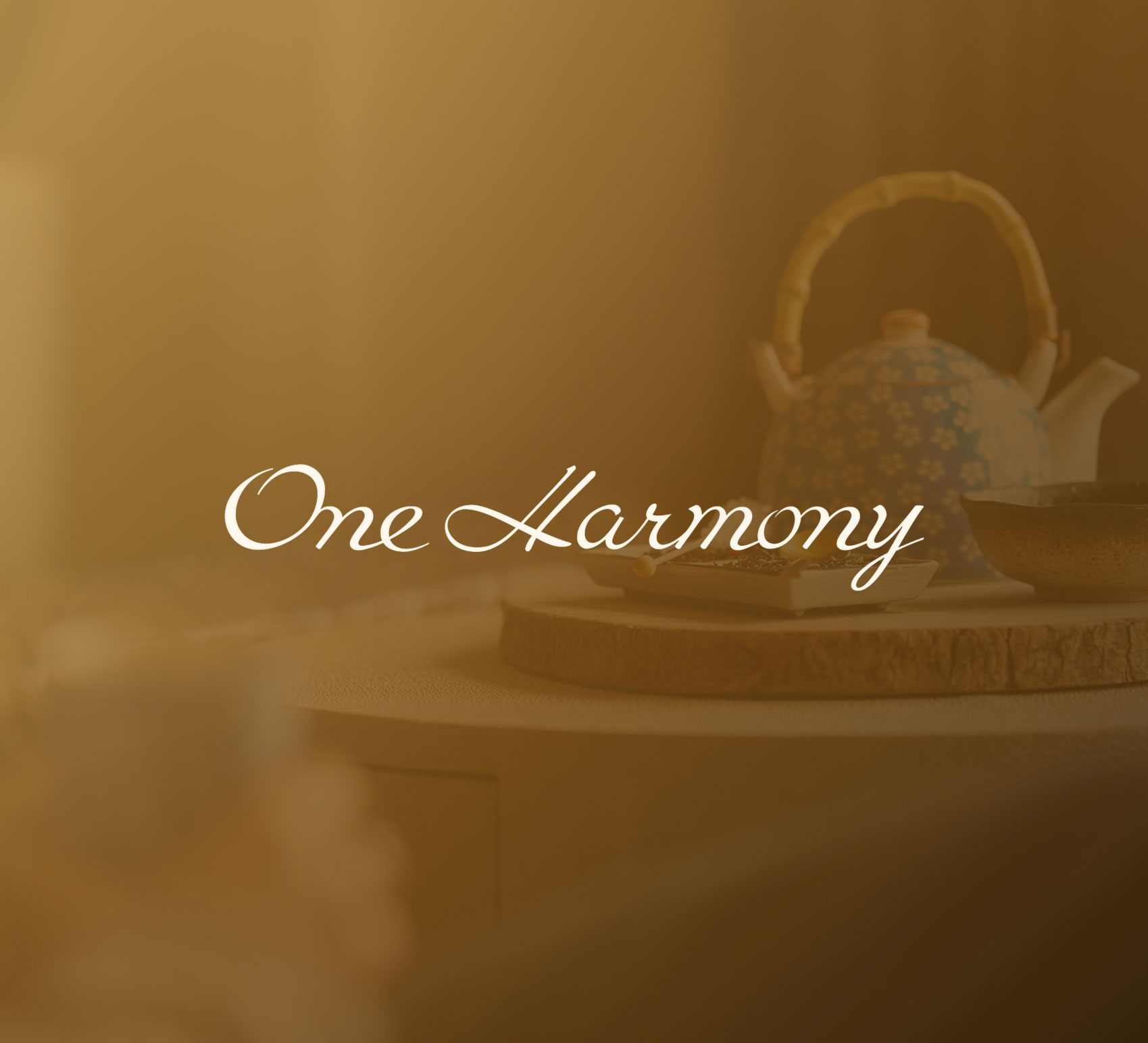 Tea set with a patterned teapot, bowl, and wooden tray, blurred behind the text One Harmony.