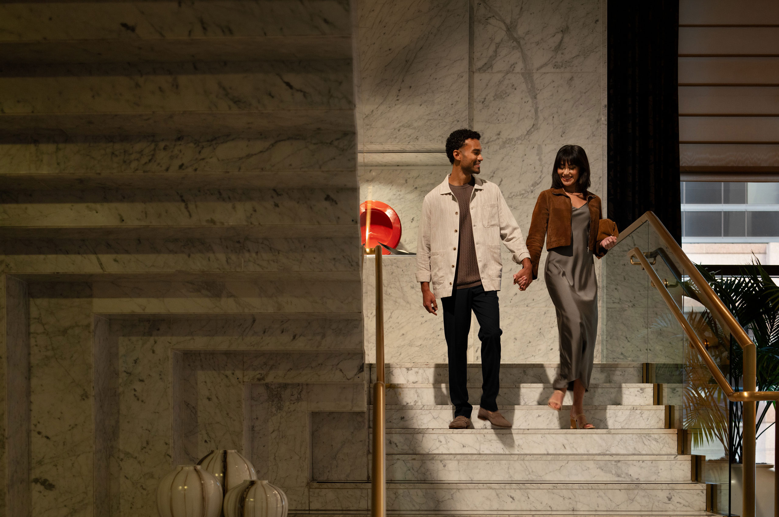 Couple holding hands on marble staircase