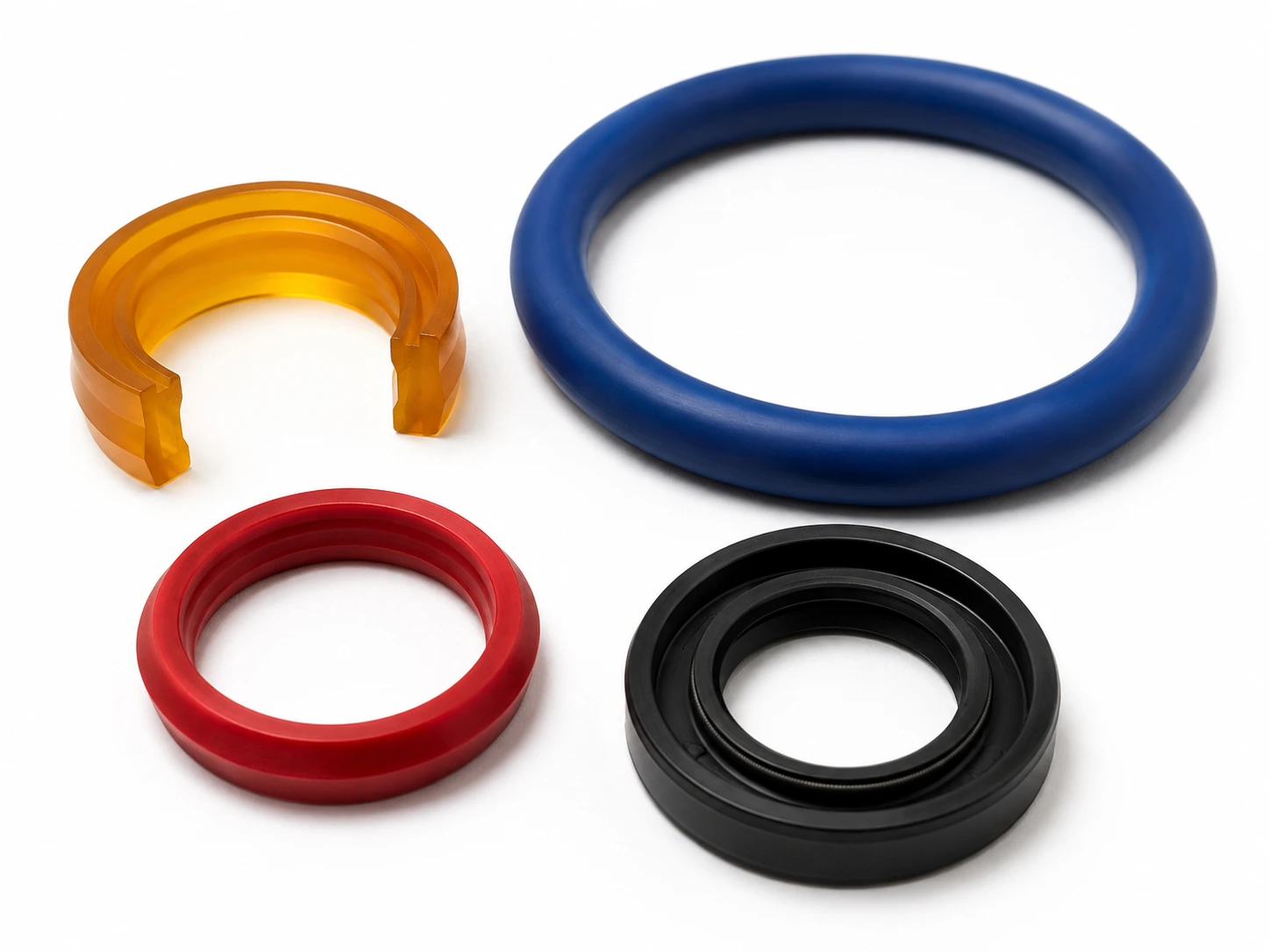 Éléments d'étanchéité en polyuréthane coulé : U-cup ambre en coupe, joint torique bleu, V-ring rouge