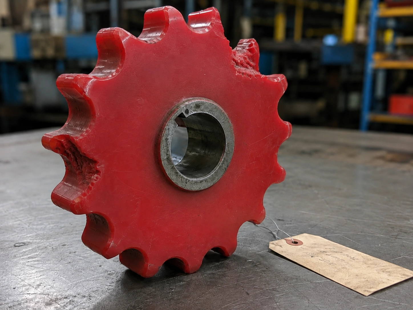 Pignon de chaîne usé en polyuréthane rouge, dents arrachées, reçu comme échantillon pour reproduction sans plan