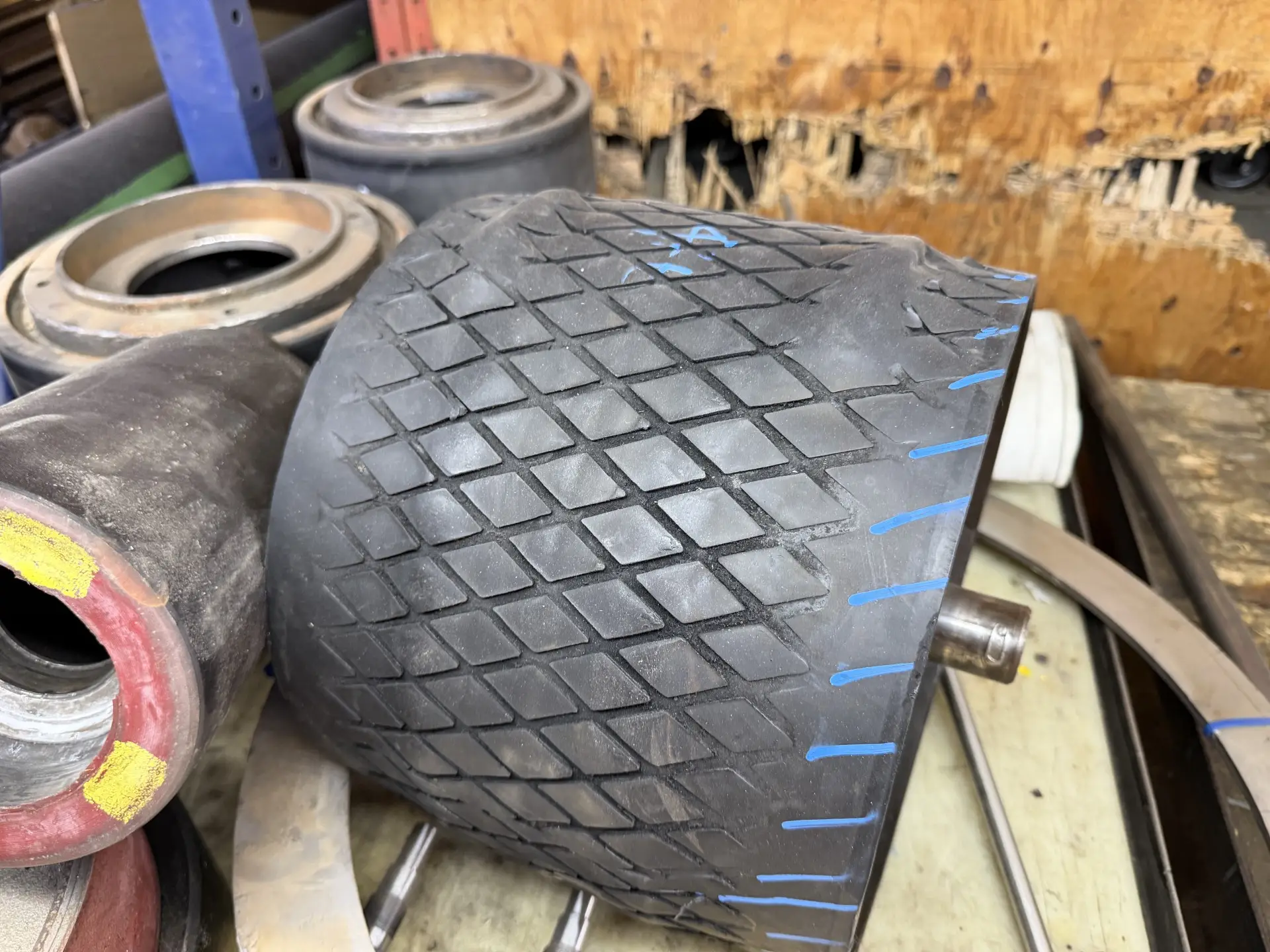 Rouleau recouvert de caoutchouc noir à rainurage diamant usé, avec repères de craie bleue pour le relevé des cotes