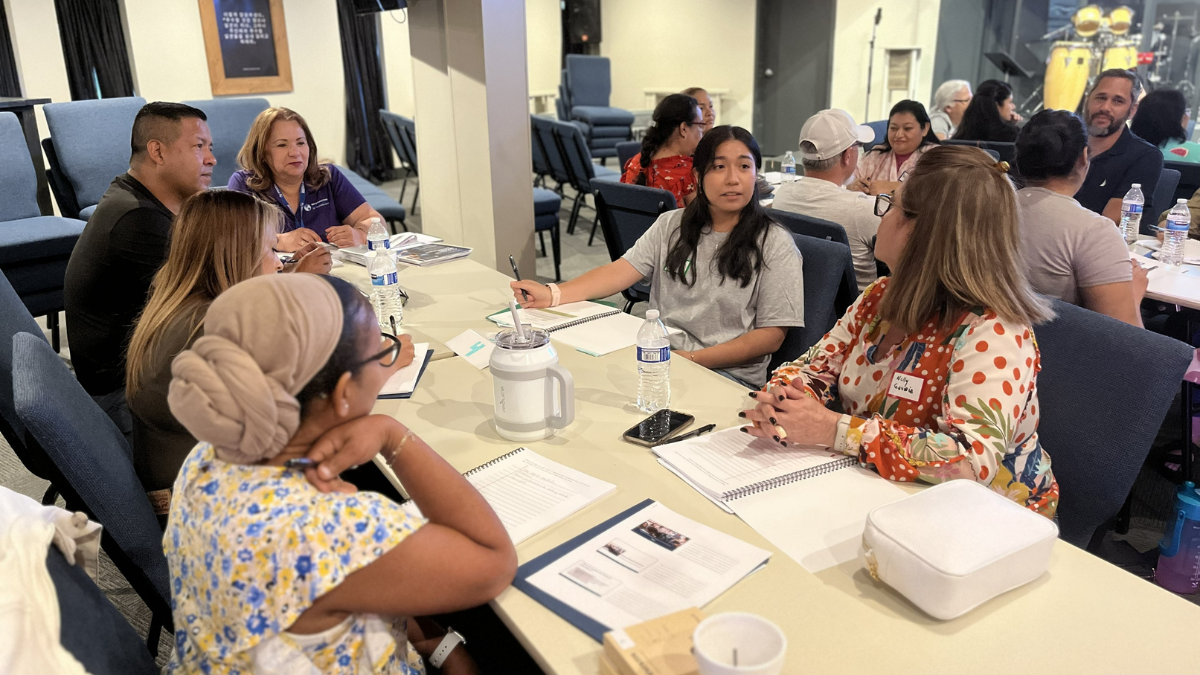 A group of people sitting at the table in a conference room.