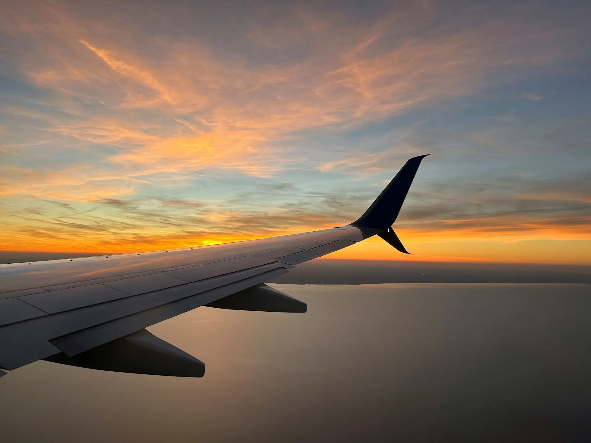 the wing of an airplane as the sun sets