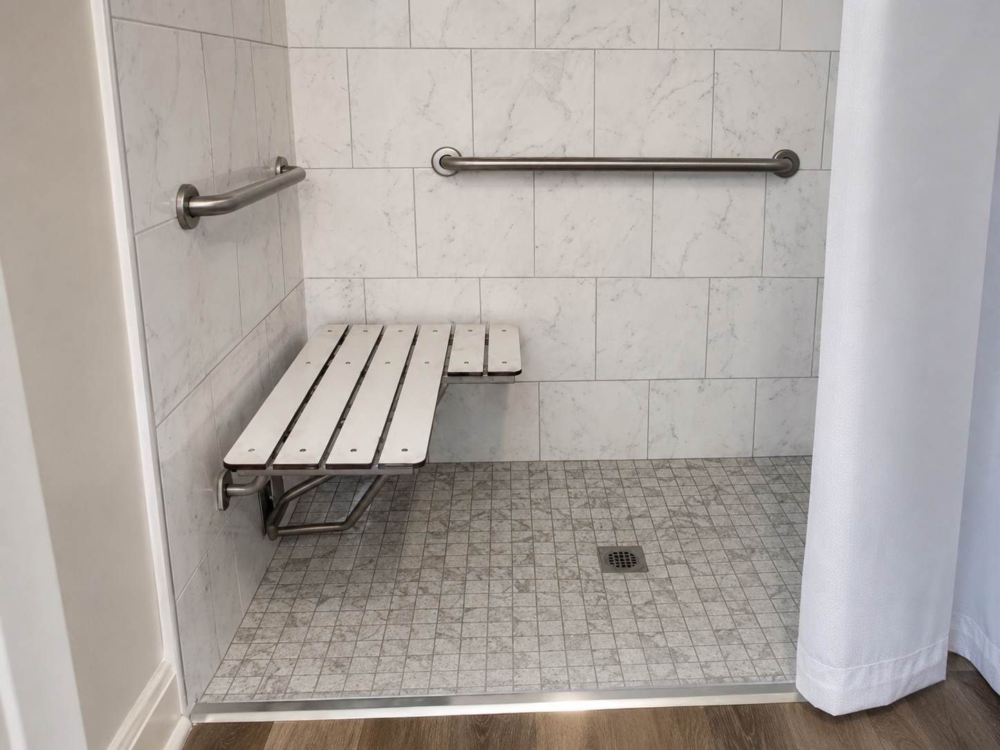Marble walk-in shower with fold-down bench by Coastal Builders Associates
