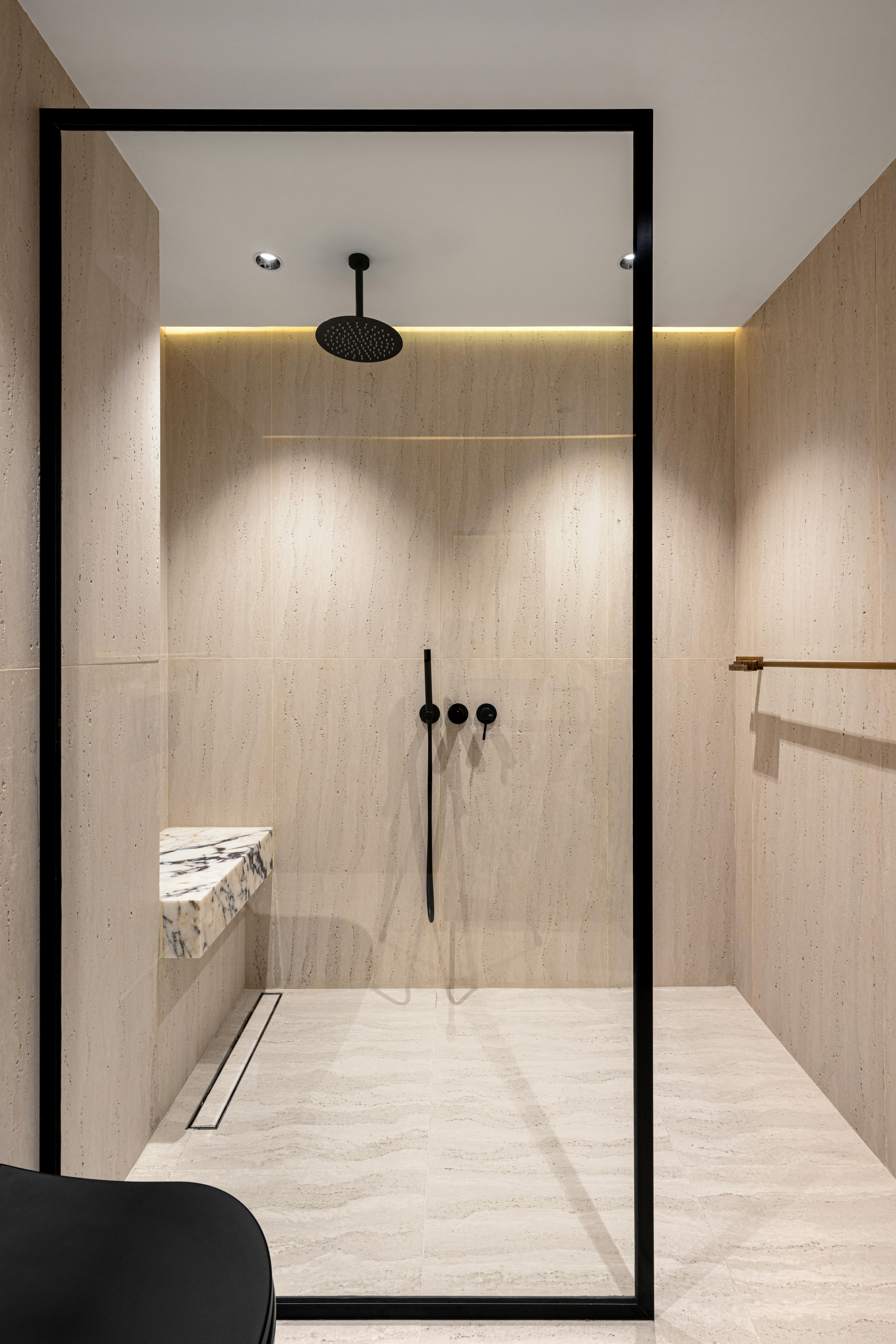 Glass-enclosed corner tile walk-in shower remodel by Coastal Builders Associates