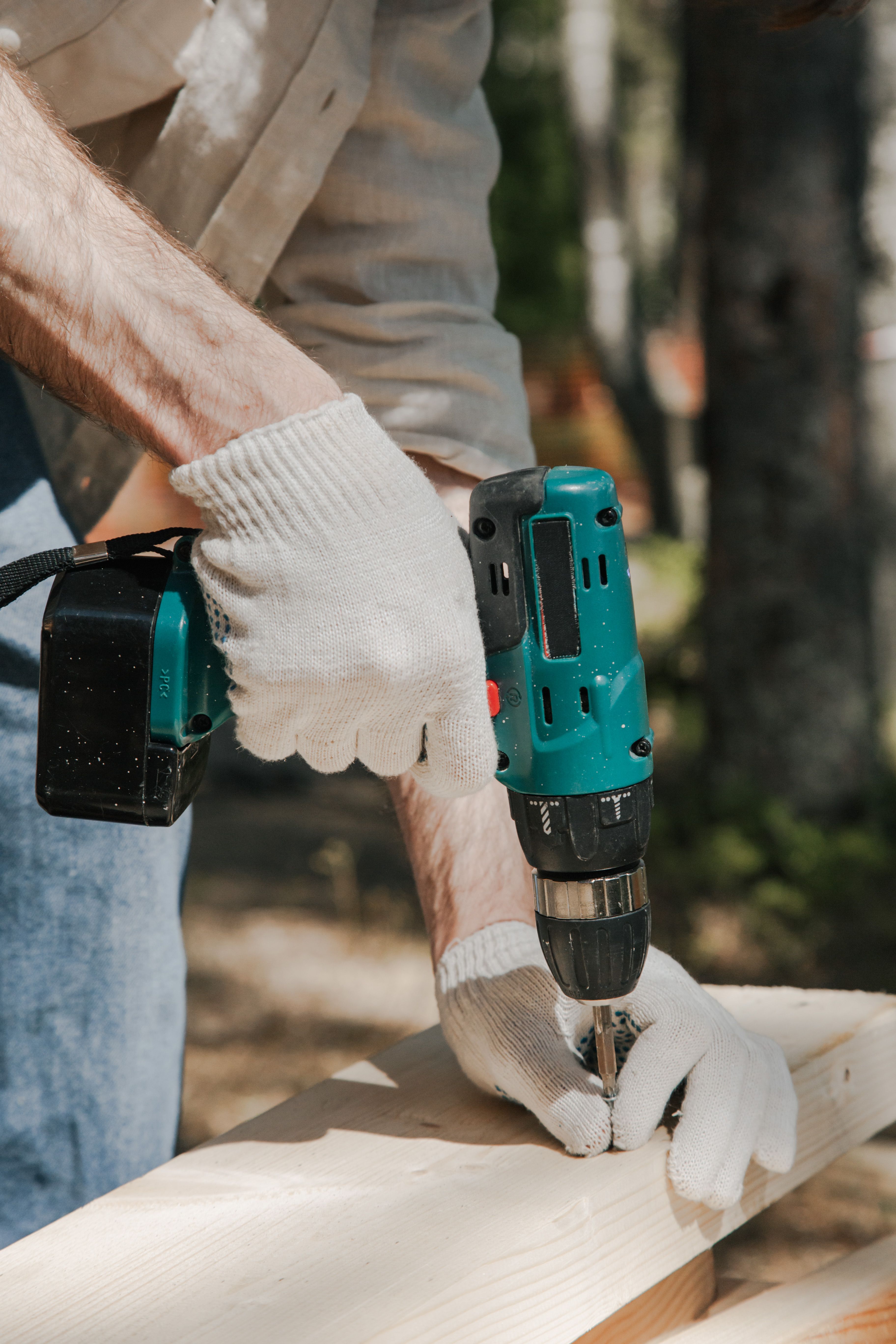Coastal Builders Associates contractor using a power drill during a bathroom remodel