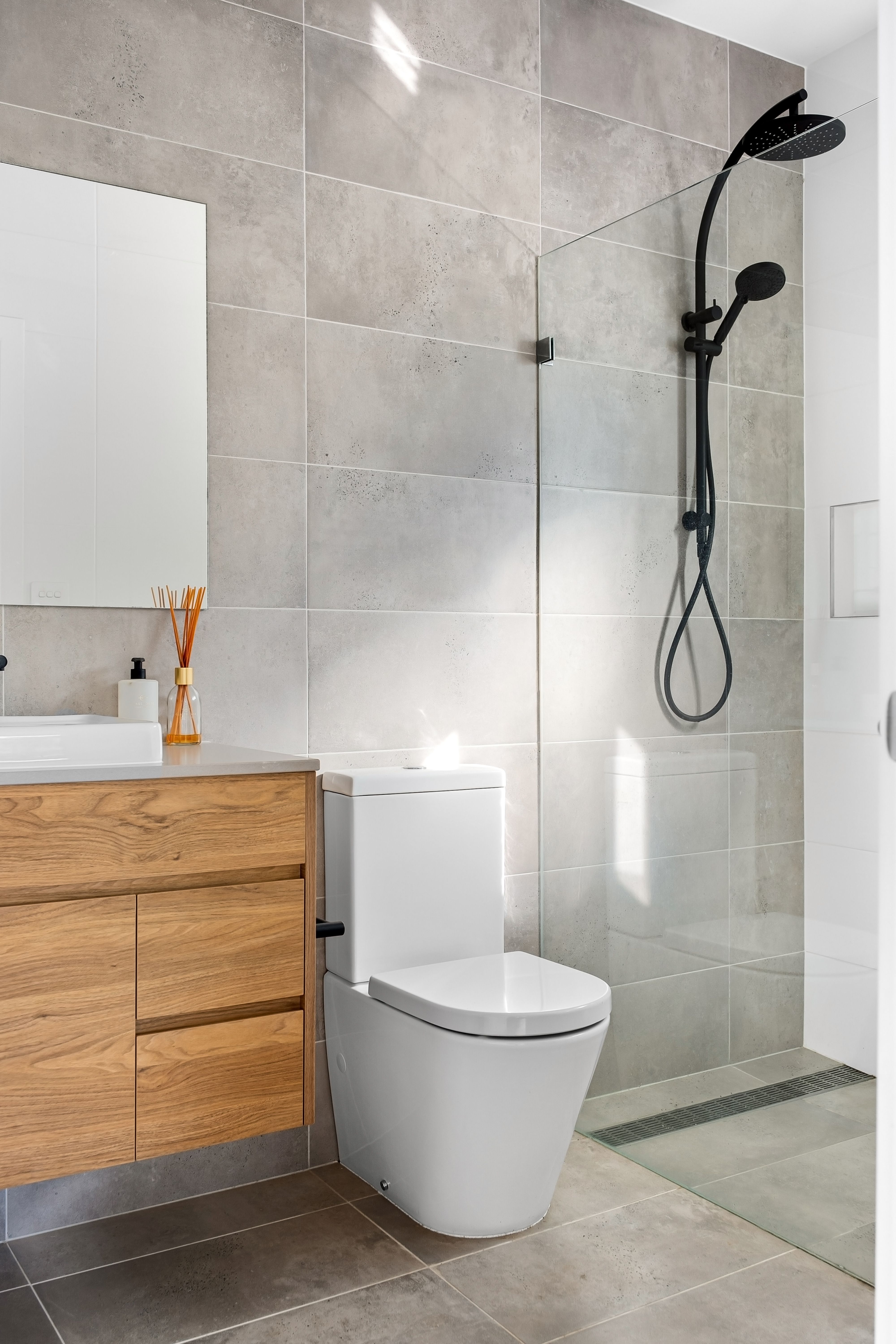 Glass-enclosed corner tile shower remodel by Coastal Builders Associates