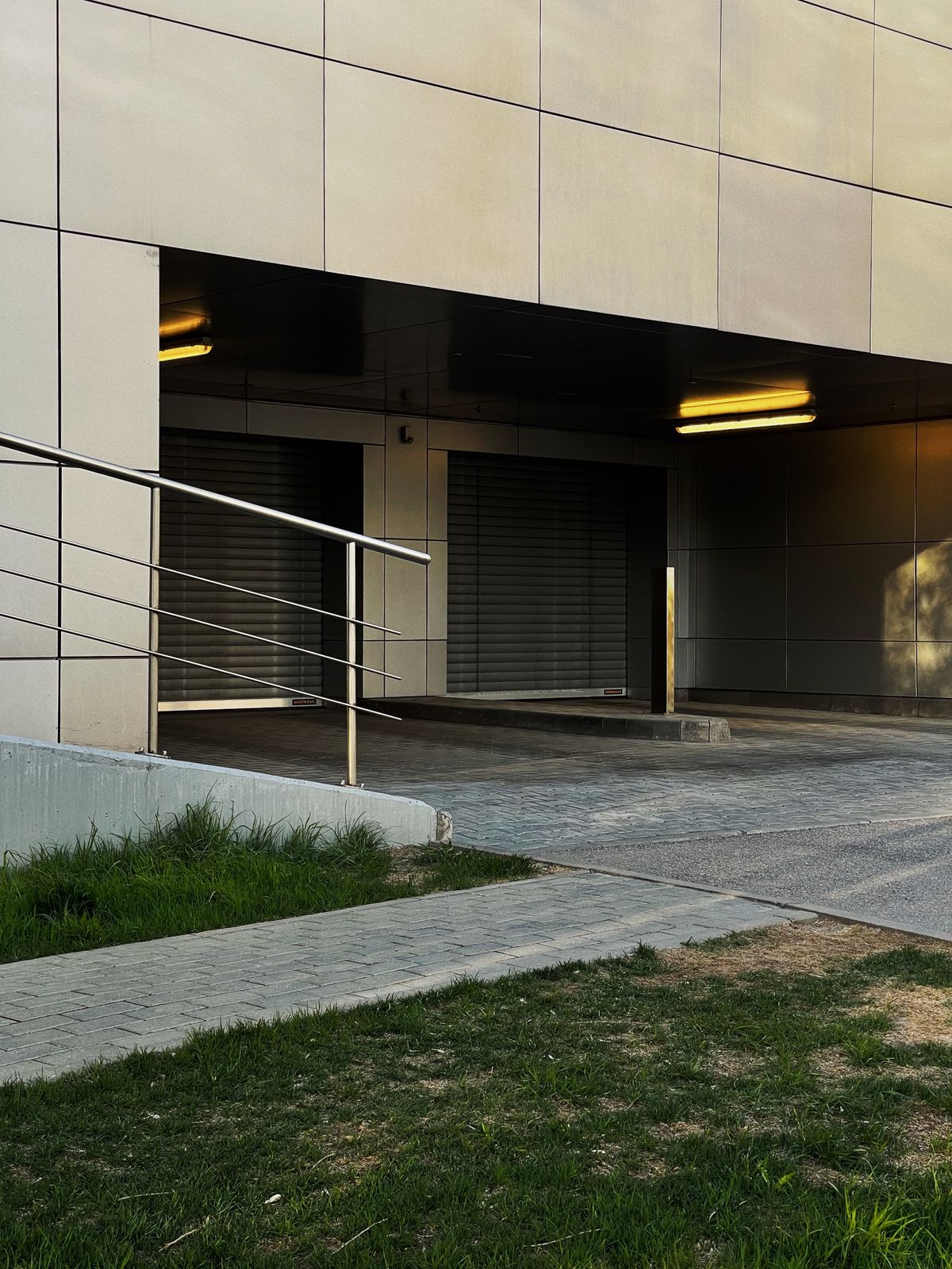 Aluminum accessibility ramp with metal railing at a building entrance