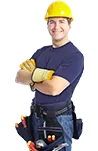 A smiling worker with arms crossed, a yellow hard hat and a tool belt