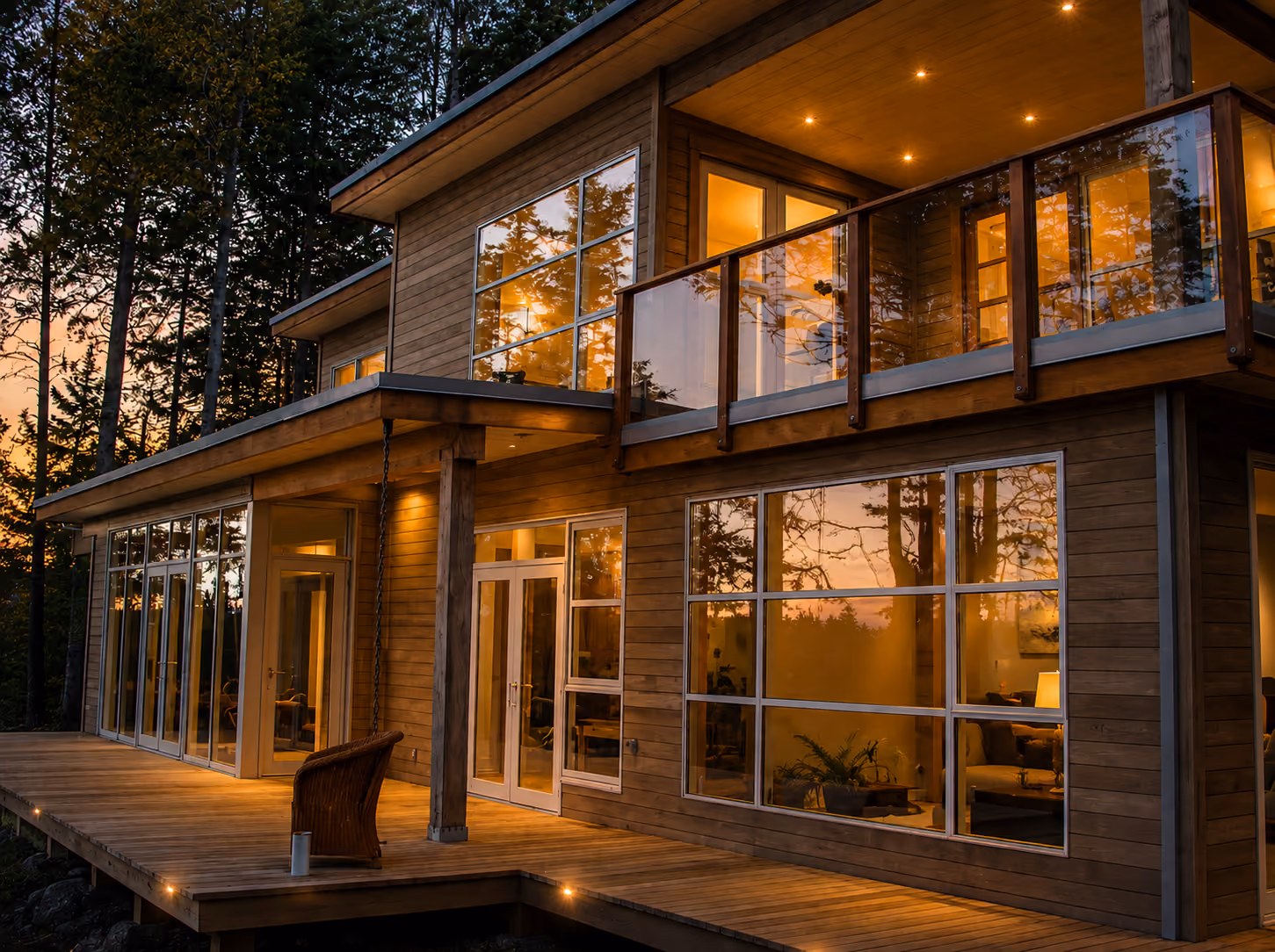 Rainstone Developments modern custom home at twilight in west coast style with lots of glass and wood