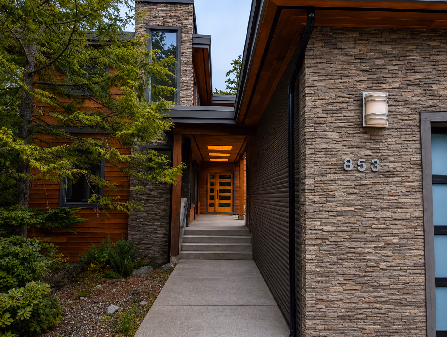 Rainstone Developments modern custom home entrance in west coast style with natural textures of wood and stone