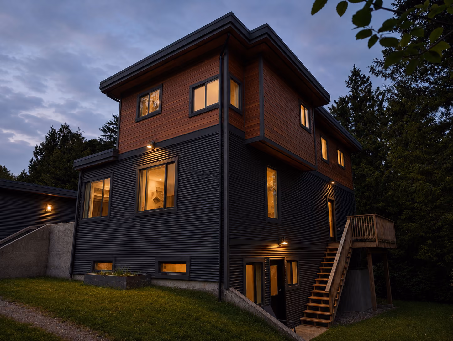 Rainstone Developments contemporary custom home at twilight in west coast style with natural textures of wood and stone