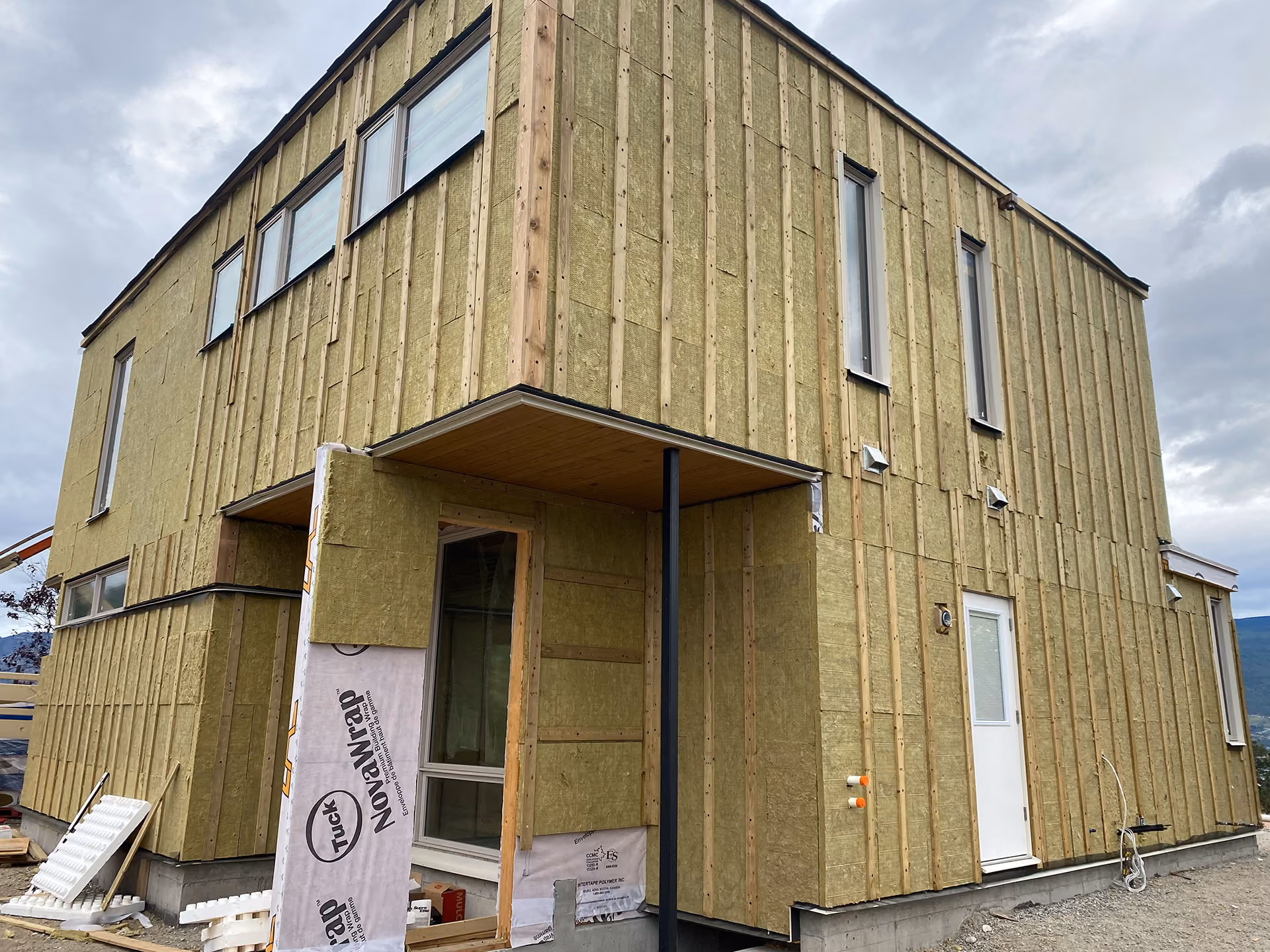 modern custom home under construction with framing and walls