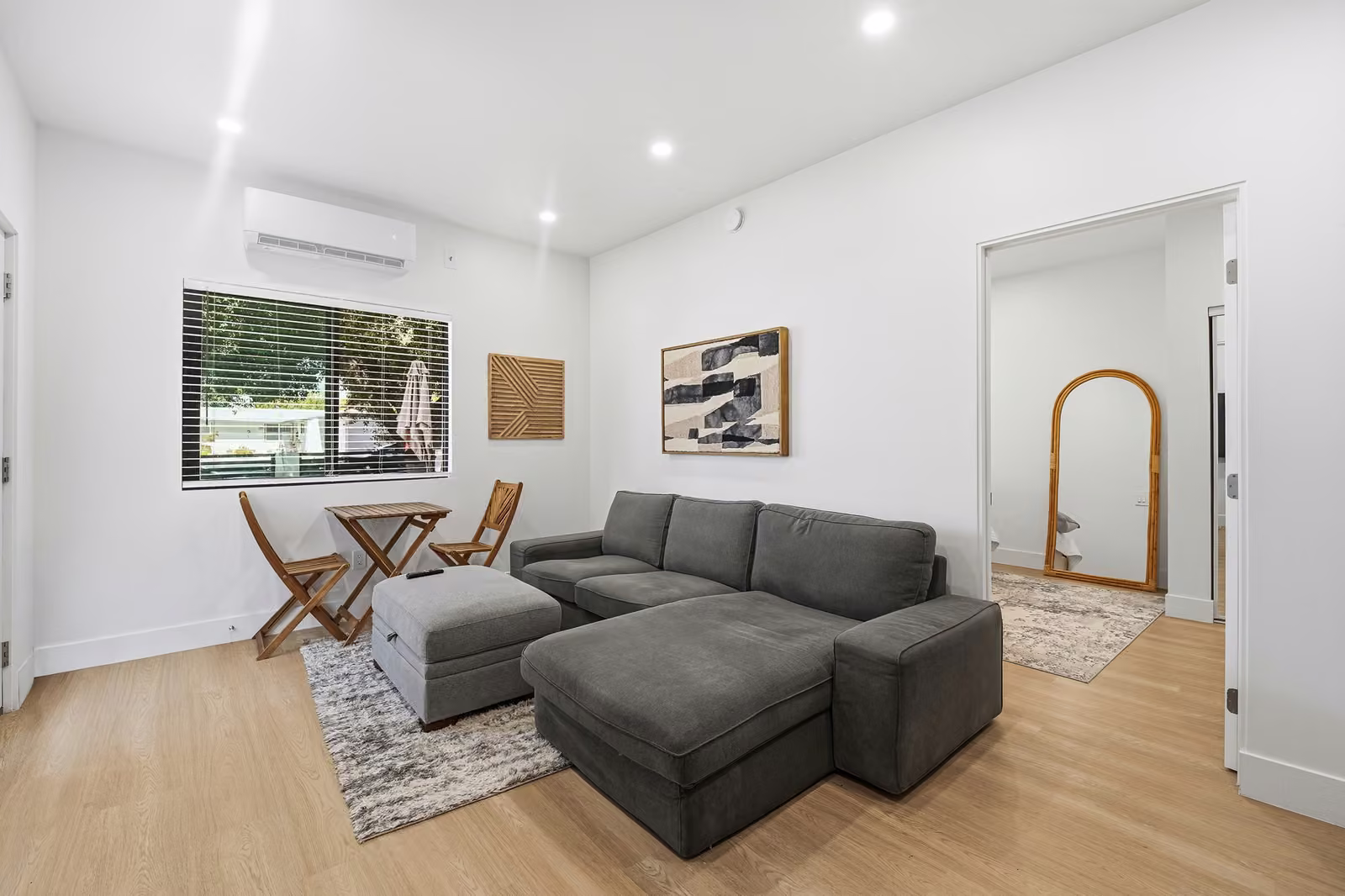 Remodeled living room with sectional sofa and light wood flooring