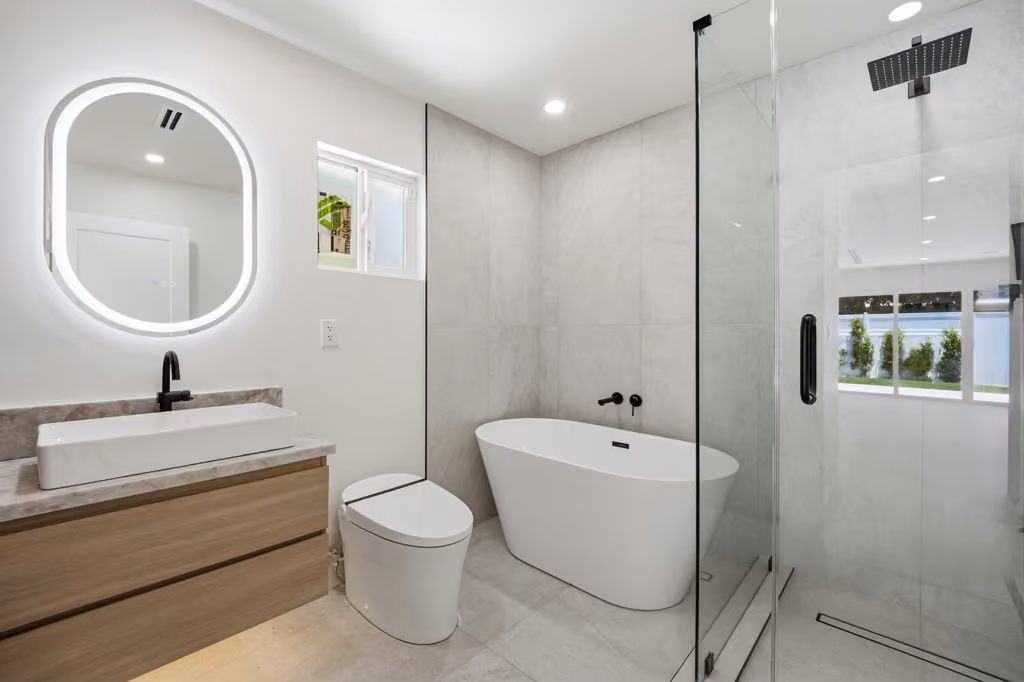 Modern bathroom with floating vanity, round mirror, and glass shower