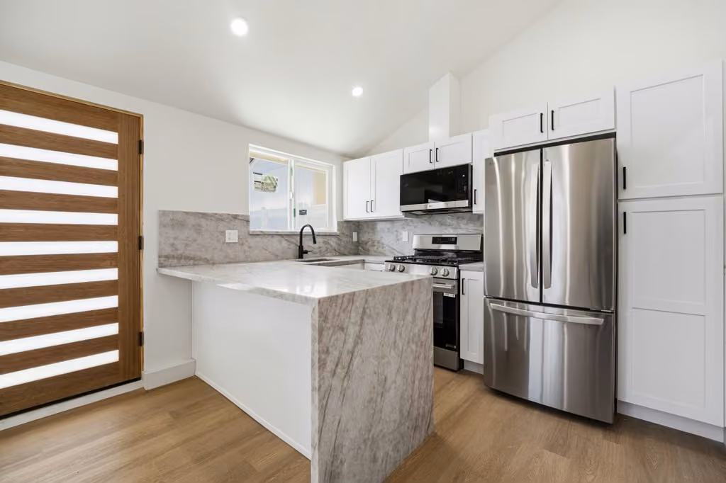 Modern kitchen with marble waterfall island and stainless steel appliances