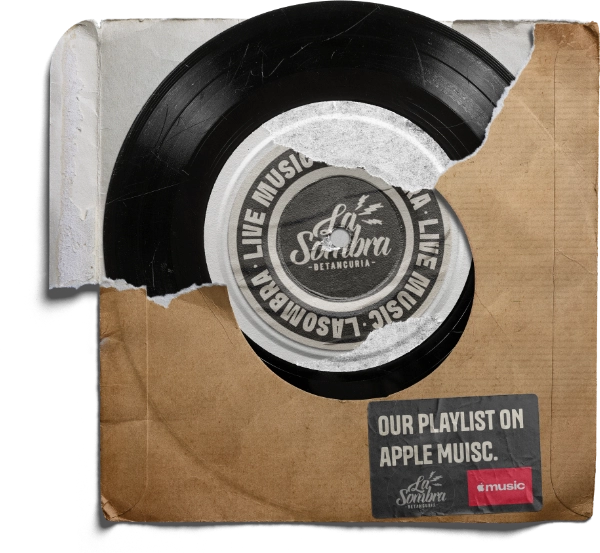 A black vinyl record partially inside a torn and worn brown paper sleeve. The record label reads 'La Sombra Betancuria' and 'Live Music La Sombra'. A sticker on the sleeve says 'Our playlist on Apple Music' with the logos for La Sombra and Apple Music.