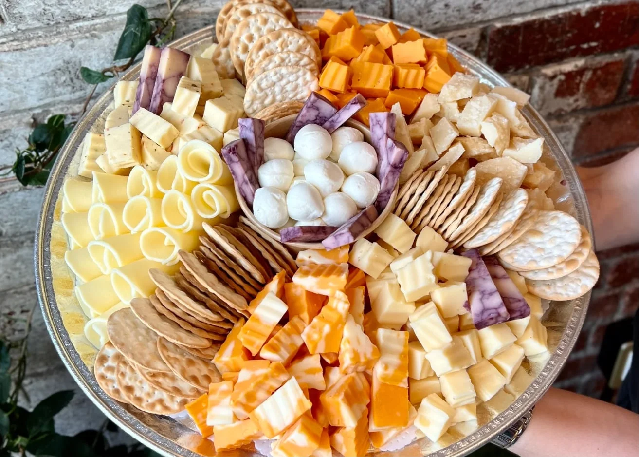 Cheese Platter with cubed hard cheese, soft cheese, mozzarella balls, and crispy crackers.