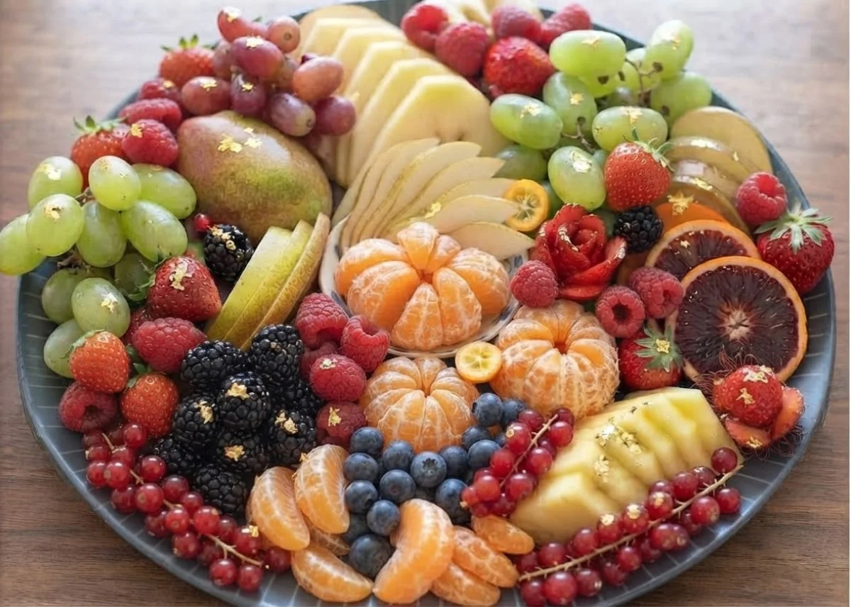 Fruit Platter arranged with sliced apples, grapes, strawberries, oranges, and seasonal fruits.