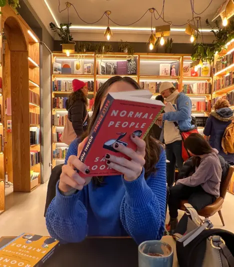 girl with book in front of face