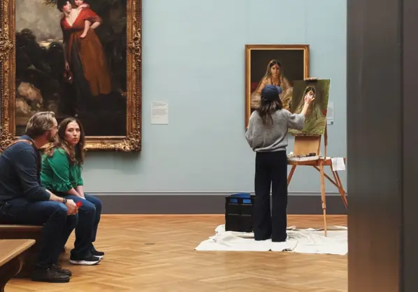 female artist painting in a museum