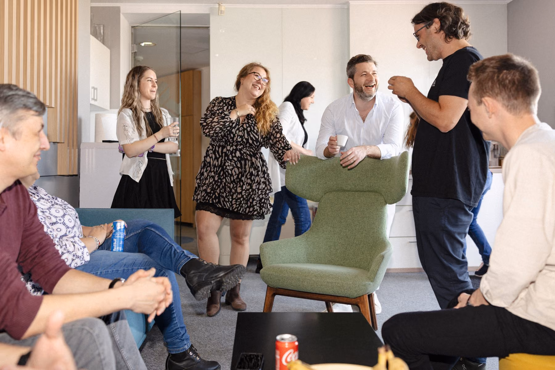 Sync team members talking and laughing together in the office lounge