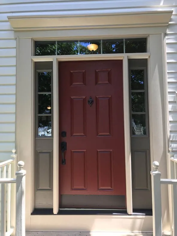 Red six-panel front door with transom and sidelites framed in white trim
