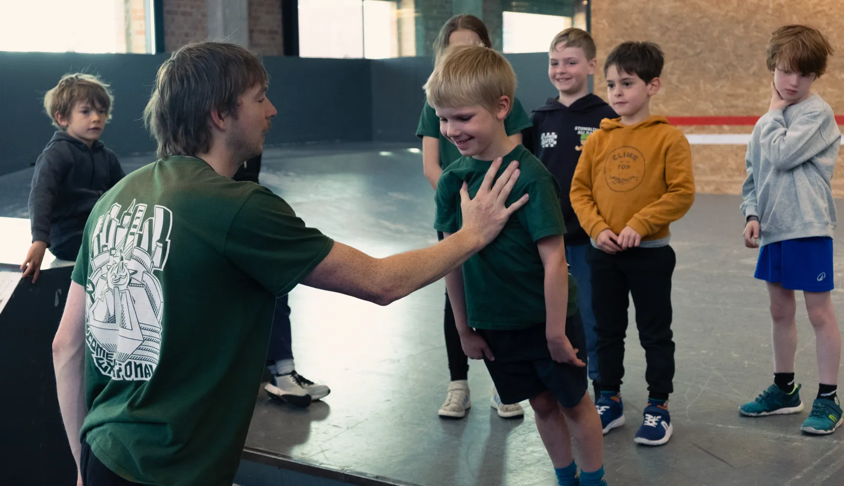 Coach en kinderen tijdens de parkourles voor kids in de sporthal
