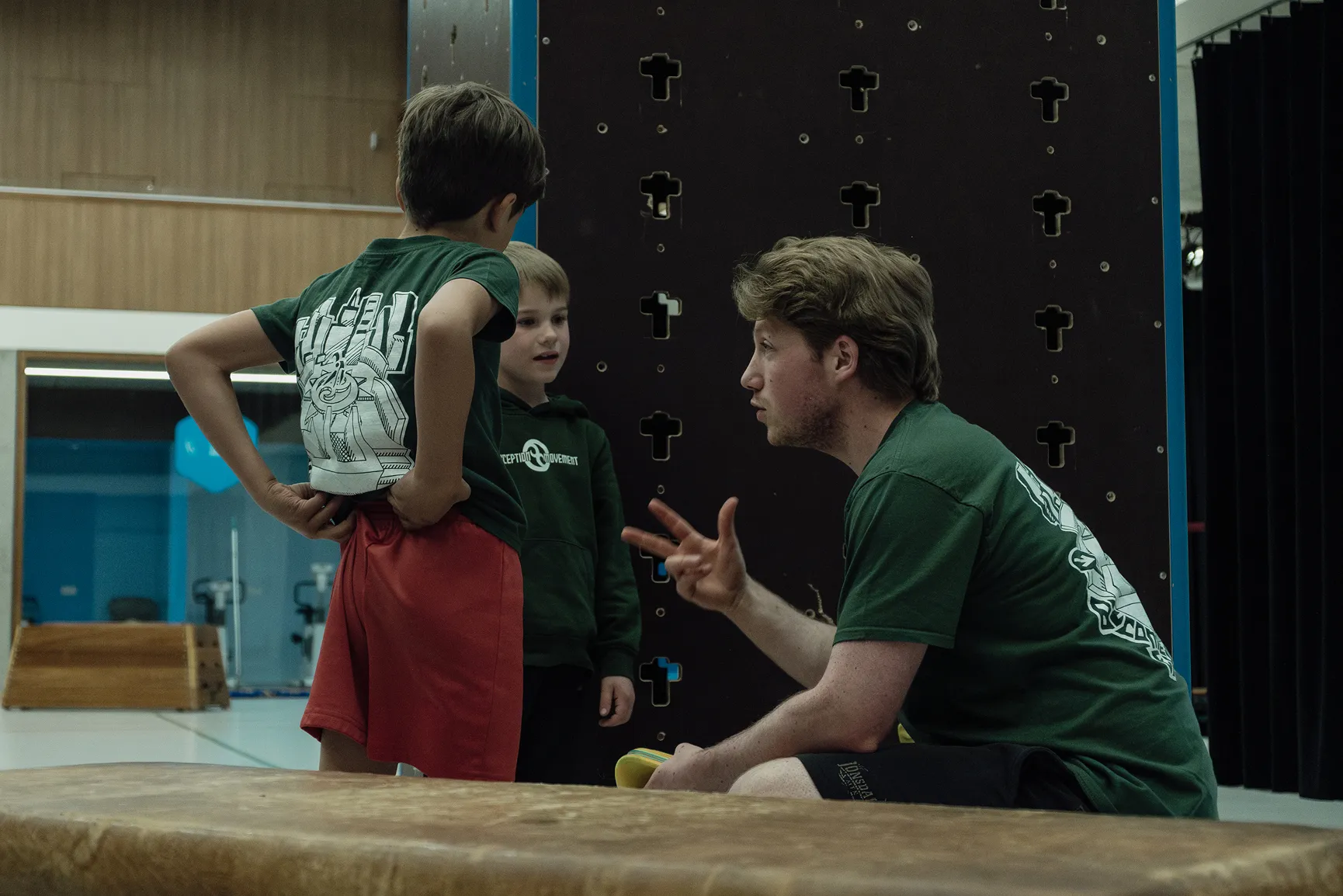 Coach legt een techniek uit aan jongeren in de indoorzaal